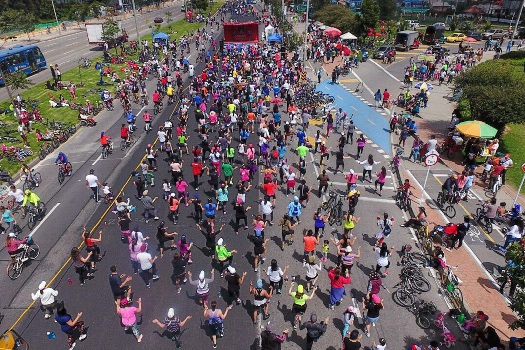 Tausende Menschen tanzen vor einer Bühne auf der Ciclovía in Bogotá